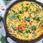 Brunch egg frittata with spinach, roasted red peppers, mushrooms, in cast iron, horizontal, top view